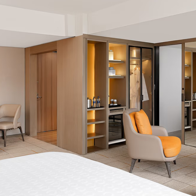 Introduction As a leading commercial furniture supplier, we offer expertly crafted wooden wardrobes designed for the hospitality industry. Engineered with solid hardwood frames and advanced features like motion-activated LED lighting, soft-close hardware, and customizable finishes, our wardrobes deliver durability, functionality, and style. Perfect for luxury hotels, resorts, corporate environments, and boutique properties, our wardrobes provide guests with enhanced convenience while maintaining high operational standards. Elevate your hotel experience with our premium wardrobes today. Specifications Specification Details Construction Material Solid hardwood with engineered core; marine-grade finishes Standard Dimensions 48 مقدمة باعتبارنا أحد الموردين الرائدين للأثاث التجاري، فإننا نقدم خزائن خشبية مصنوعة بخبرة ومصممة لصناعة الضيافة. تم تصميم دواليب الملابس لدينا بإطارات من الخشب الصلب وميزات متقدمة مثل إضاءة LED التي يتم تنشيطها بالحركة، وأجهزة الإغلاق الناعمة، والتشطيبات القابلة للتخصيص، وتوفر المتانة والوظيفة والأناقة. تعتبر خزائن الملابس لدينا مثالية للفنادق الفاخرة والمنتجعات وبيئات الشركات والعقارات البوتيكية، وتوفر للضيوف راحة معززة مع الحفاظ على معايير تشغيلية عالية. ارفع مستوى تجربتك الفندقية مع خزائن الملابس المتميزة لدينا اليوم. المواصفات تفاصيل المواصفات مواد البناء خشب صلب صلب ذو قلب هندسي؛ تشطيبات من الدرجة البحرية، الأبعاد القياسية 48 بوصة - 192 بوصة عرض × 24 بوصة عمق × 84 بوصة ارتفاع؛ أحجام مخصصة لمشاريع FF&E التكوين الداخلي أرفف قابلة للتعديل وقضبان تعليق وإكسسوارات قابلة للسحب أنظمة الأجهزة مفصلات Blum الناعمة الإغلاق؛ شرائح كاملة التمديد (200 رطل) إضاءة LED شرائط تعمل بالحركة؛ 12 فولت الجهد المنخفض. أكثر من 60,000 ساعة من تصنيف السلامة من الحرائق، معالجة مقاومة للحريق من الدرجة أ؛ خيارات اللمسات النهائية المتوافقة مع حسن الضيافة: أكثر من 25 نوعًا من الأخشاب؛ عدد غير محدود من البقع والطلاءات المخصصة سعة الوزن 250 رطلاً لكل قدم خطي؛ 75 رطلاً لكل رف قابل للتعديل. طريقة التجميع: نظام قفل الكامة المعياري؛ مكونات مثقوبة بدقة. الميزات الكهربائية: محول 12 فولت؛ أجهزة استشعار الحركة تكامل شحن USB، الاستدامة، خشب معتمد من مجلس رعاية الغابات (FSC)؛ المرحلة الثانية من كارب؛ تشطيبات منخفضة المركبات العضوية المتطايرة. تغطية الضمان هيكلية لمدة 12 عامًا؛ أجهزة لمدة 7 سنوات؛ الميزات والفوائد الإلكترونية لمدة 5 سنوات متانة من الدرجة التجارية وبنية فائقة تم تصميم هذه الخزائن بإطارات من الخشب الصلب وتشطيبات من الدرجة البحرية، لتتحمل الاستخدام اليومي المكثف لأكثر من 20 عامًا، مما يوفر عمرًا أطول من الأثاث السكني بنسبة 40%. مثالية لبيئات الضيافة ذات حركة المرور العالية، مما يضمن المتانة على المدى الطويل. تكامل LED المتقدم وتقنية التخزين الذكية لا توفر أنظمة الإضاءة LED التي تعمل بالحركة والتي يبلغ عمرها الافتراضي 60,000 ساعة إضاءة أنيقة فحسب، بل تقلل أيضًا من استهلاك الطاقة بنسبة 85%. تعمل محطات الشحن المدمجة والملحقات القابلة للسحب والأرفف القابلة للتعديل على تحسين كفاءة التخزين وتعزيز راحة الضيوف. أجهزة فائقة الإغلاق وناعمة وتقليل الضوضاء تعمل آليات Blum المصممة هندسيًا ألمانيًا على التخلص من أصوات الصفق، مما يقلل من انتقال الضوضاء بنسبة 98%. وهذا يخلق بيئة هادئة للضيوف، ومثالية لأنشطة وقت متأخر من الليل أو في الصباح الباكر. تكامل FF&E قابل للتخصيص ومرونة التصميم مع أكثر من 25 نوعًا من الأخشاب وخيارات طلاء مخصصة غير محدودة، يمكنك تصميم خزانات الملابس هذه لتناسب جمالية علامتك التجارية. تستوعب التكوينات المعيارية من 4 إلى 16 بوصة تخطيطات الغرف ومعايير التصميم المتنوعة. التصنيع المستدام والامتثال البيئي نحن نستخدم الخشب المعتمد من FSC، والتشطيبات منخفضة المركبات العضوية المتطايرة، والطاقة المتجددة في عملية التصنيع، مما يضمن أن خزانات الملابس تلبي معايير الامتثال البيئي لمشاريع المباني الخضراء. التطبيقات غرف نوم الأجنحة الفندقية الفاخرة: توفر حلول تخزين أنيقة وفعالة للضيوف المقيمين لفترات طويلة، مع إضاءة متكاملة ومحطات شحن لتعزيز تجربة الرفاهية. خصائص المنتجع والإقامة الممتدة: تتميز بتشطيبات مقاومة للطقس وتخطيطات قابلة للتخصيص، مثالية لتخزين الملابس الموسمية والمعدات الترفيهية. بيئات الفنادق الخاصة بالشركات: مصممة خصيصًا لتلبية احتياجات المسافرين من رجال الأعمال، بما في ذلك مقصورات لملابس العمل وإمكانيات الشحن المتكاملة. فنادق البوتيك والتصميم: تقدم حلول تخزين مخصصة، مع تشطيبات وتكوينات مخصصة تعكس الطابع الفريد لعقارات البوتيك. س: هل يمكن تخصيص أبعاد خزانة الملابس الخشبية لمشاريع FF&E الفريدة؟ ج: نعم، التصميم المعياري يستوعب العرض من 4 إلى 16 بوصة والارتفاعات المخصصة حتى 12 بوصة، مع خيارات تكوين غير محدودة مصممة خصيصًا لتطبيقات أثاث الضيافة. س: ما هي التشطيبات الخشبية المتاحة لمشاريع موردي الأثاث التجاري؟ ج: اختر من بين أكثر من 25 نوعًا من الأخشاب، بما في ذلك البلوط والجوز والكرز والماهوجني، مع خيارات غير محدودة للطلاء والورنيش المخصص لتتوافق تمامًا مع متطلبات تصميم خزانة ملابس الفندق. س: كيف تعمل آليات الإغلاق الناعم على تعزيز تجربة أثاث الضيافة؟ ج: تعمل الأجهزة الأوروبية المتميزة على التخلص من الأصوات الصاخبة، مما يقلل من انتقال الضوضاء بنسبة 98% للحفاظ على بيئات هادئة للضيوف خلال جميع ساعات التشغيل. س: هل أنظمة الإضاءة LED موفرة للطاقة لتطبيقات خزانة الملابس في الفندق؟ ج: تستهلك شرائط LED التي يتم تنشيطها بالحركة طاقة أقل بنسبة 85% من الإضاءة التقليدية مع توفير عمر افتراضي يزيد عن 60,000 ساعة، مما يقلل بشكل كبير من تكاليف الصيانة والتشغيل. س: ما هي تغطية الضمان التي تحمي استثمارات مشاريع FF&E؟ ج: تشمل التغطية الشاملة ضمانات هيكلية لمدة 12 عامًا، و7 سنوات على الأجهزة، و5 سنوات على الإلكترونيات مع دعم فني مخصص لموردي الأثاث التجاري لتطبيقات الضيافة.